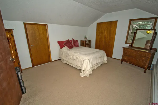 a bedroom with a bed window and mirror