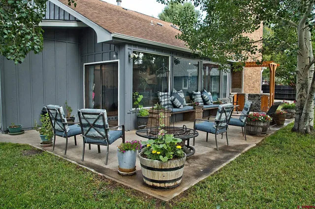 a view of a patio with couches table and chairs and potted plants