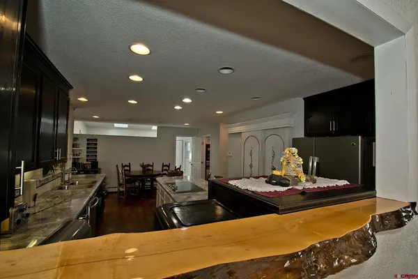a kitchen with large pool table and chairs