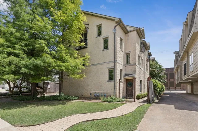 a front view of a house with a garden and trees