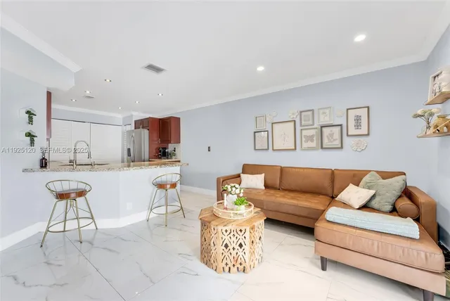a living room with furniture and view of kitchen