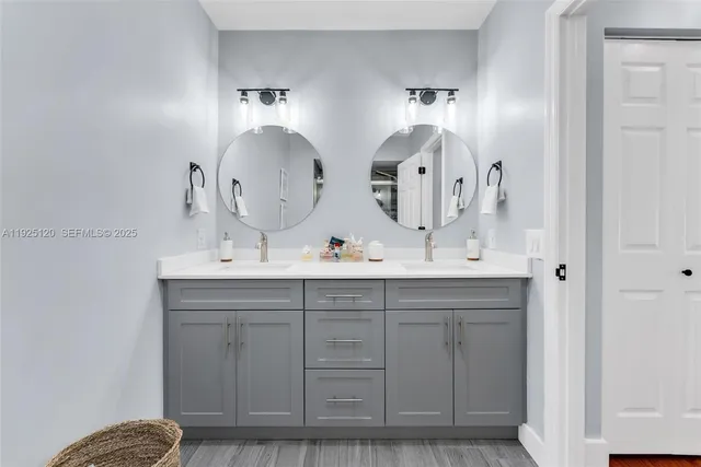a bathroom with double vanity sinks and a mirror