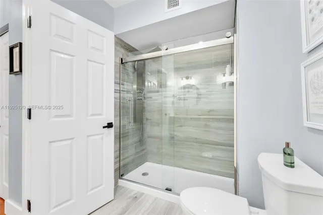 a bathroom with a shower a toilet and a sink