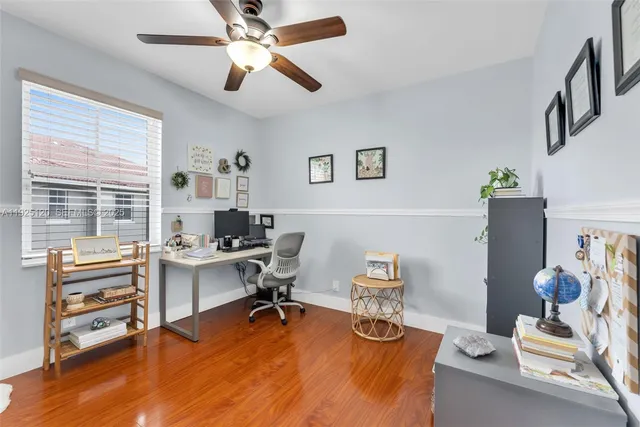 a view of a workspace with furniture and a window