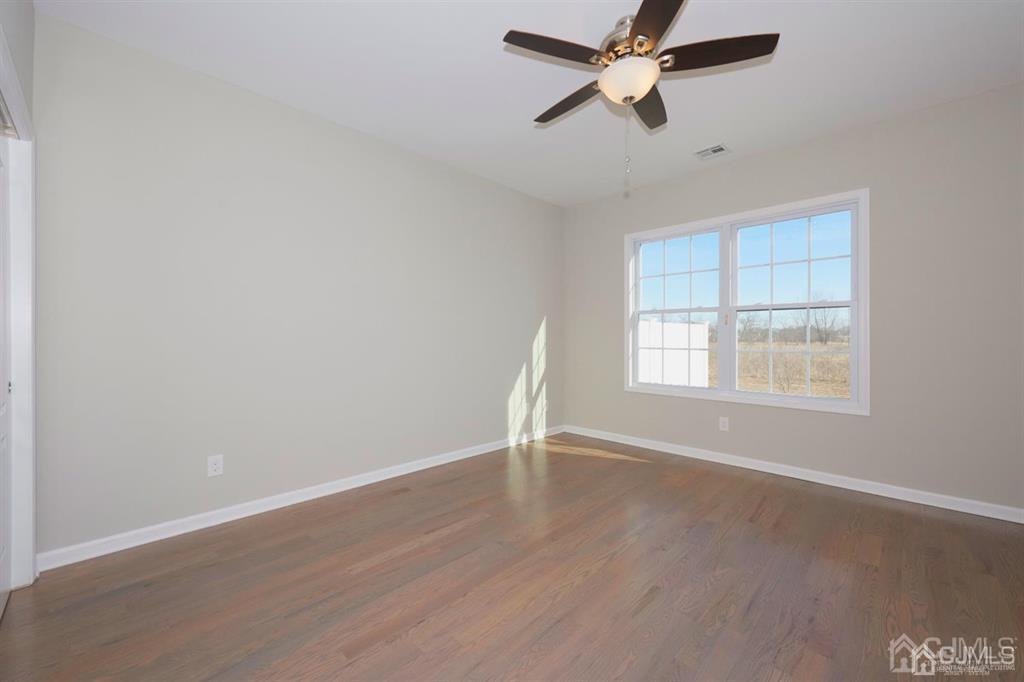 22 Green Tree Circle Hazlet, NJ 07730 - Photo 14 of 39 an empty room with wooden floor ceiling fan and windows