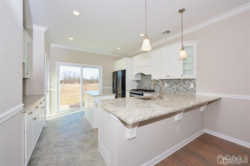 22 Green Tree Circle Hazlet, NJ 07730 - Photo 3 of 39 a kitchen with stainless steel appliances granite countertop a sink a stove and a wooden floor