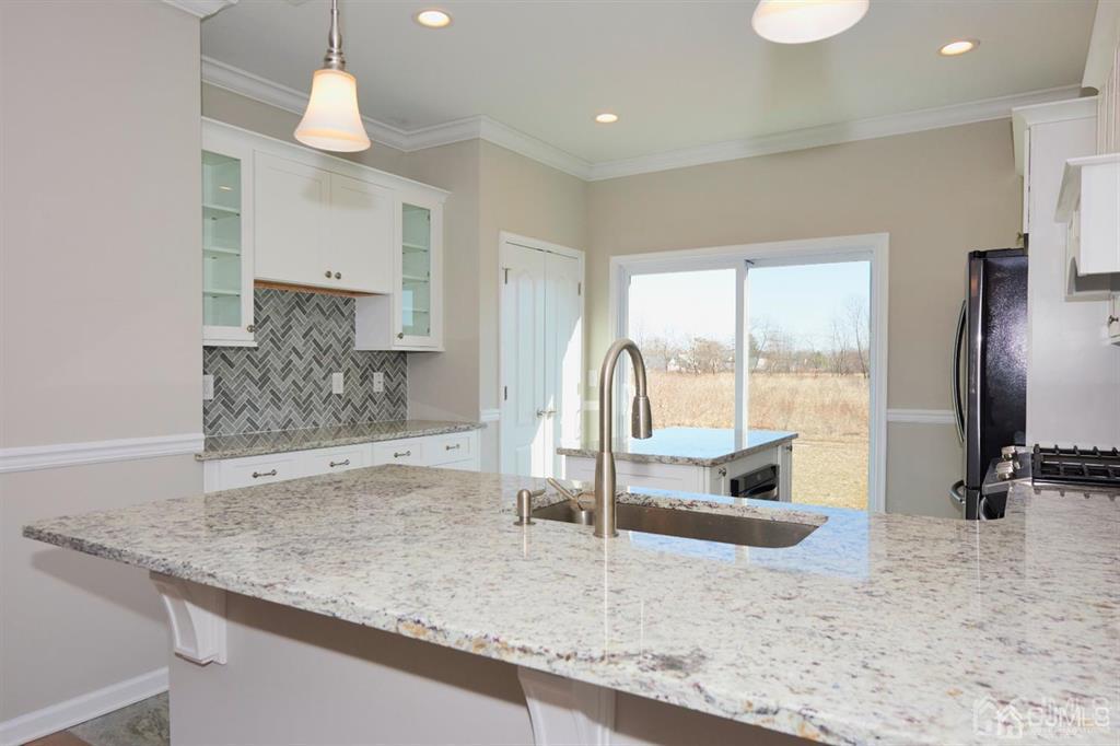 22 Green Tree Circle Hazlet, NJ 07730 - Photo 5 of 39 a kitchen with granite countertop a sink a counter and a refrigerator