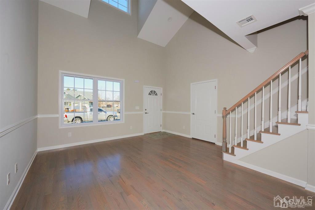 22 Green Tree Circle Hazlet, NJ 07730 - Photo 7 of 39 a view of an empty room with wooden floor and a window