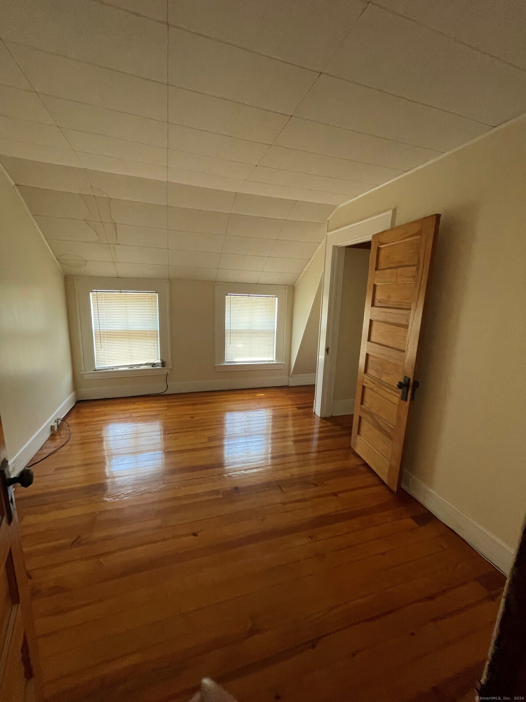 22 Fairview Street Milford, CT 06460 - Photo 15 of 28 a view of empty room with window and wooden floor