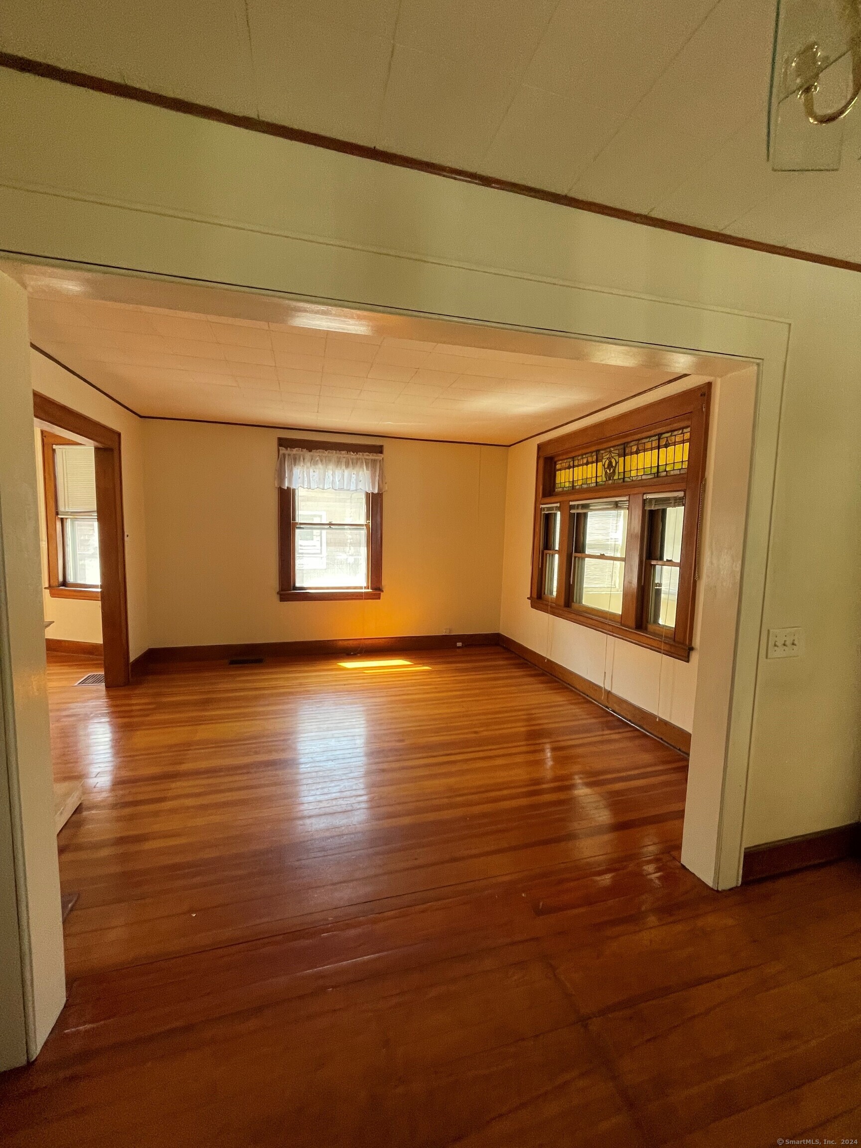22 Fairview Street Milford, CT 06460 - Photo 7 of 28 a view of an empty room with window and wooden floor