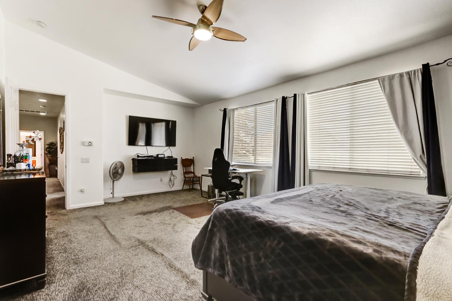 9820 Spring View Way Elk Grove, CA 95757 - Photo 31 of 49 a spacious bedroom with a bed a table and large mirror