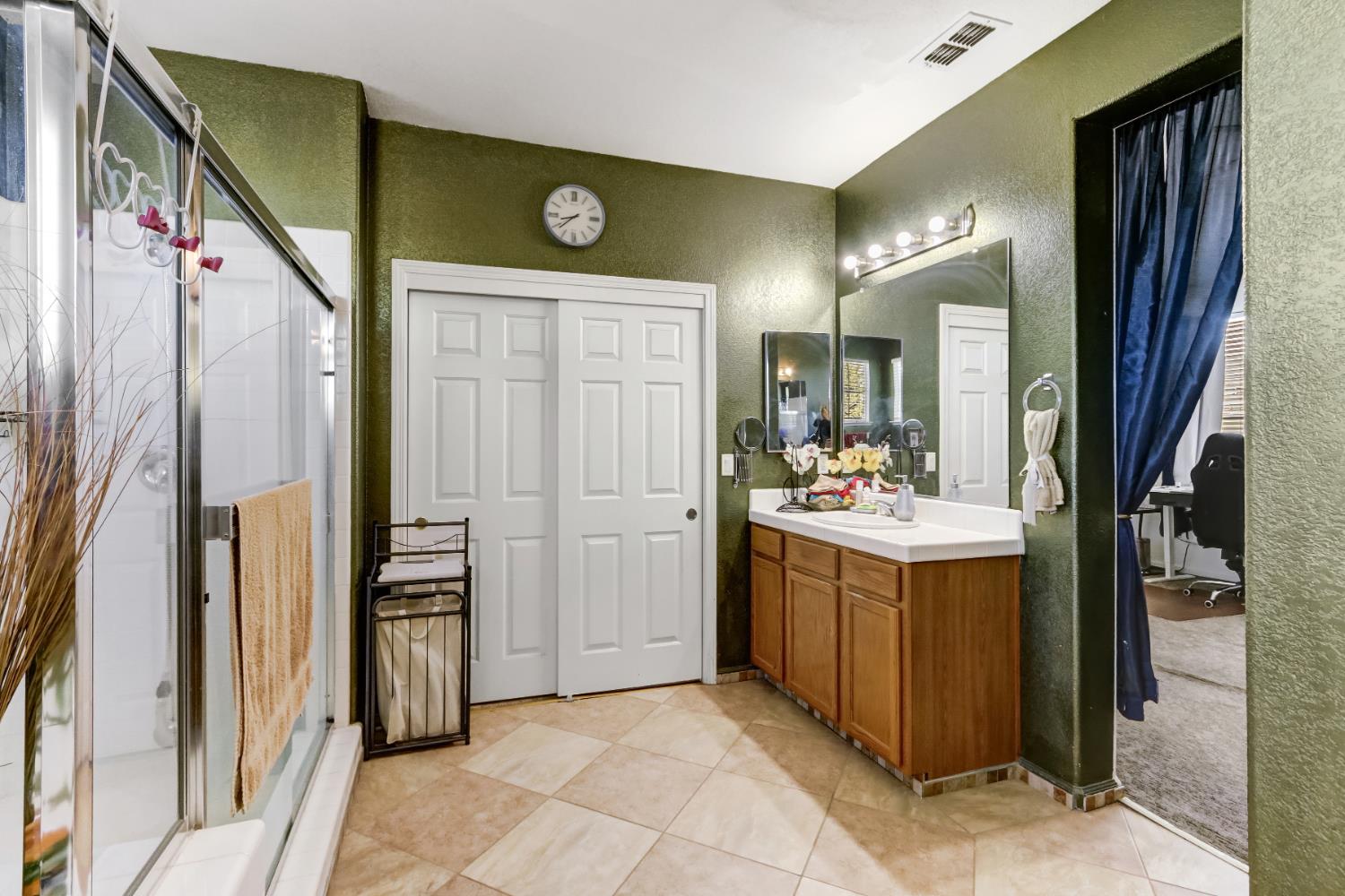 9820 Spring View Way Elk Grove, CA 95757 - Photo 34 of 49 a bathroom with a sink a mirror and a shower
