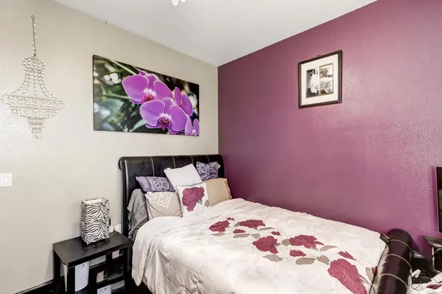 a bedroom with a bed and a painting on the wall