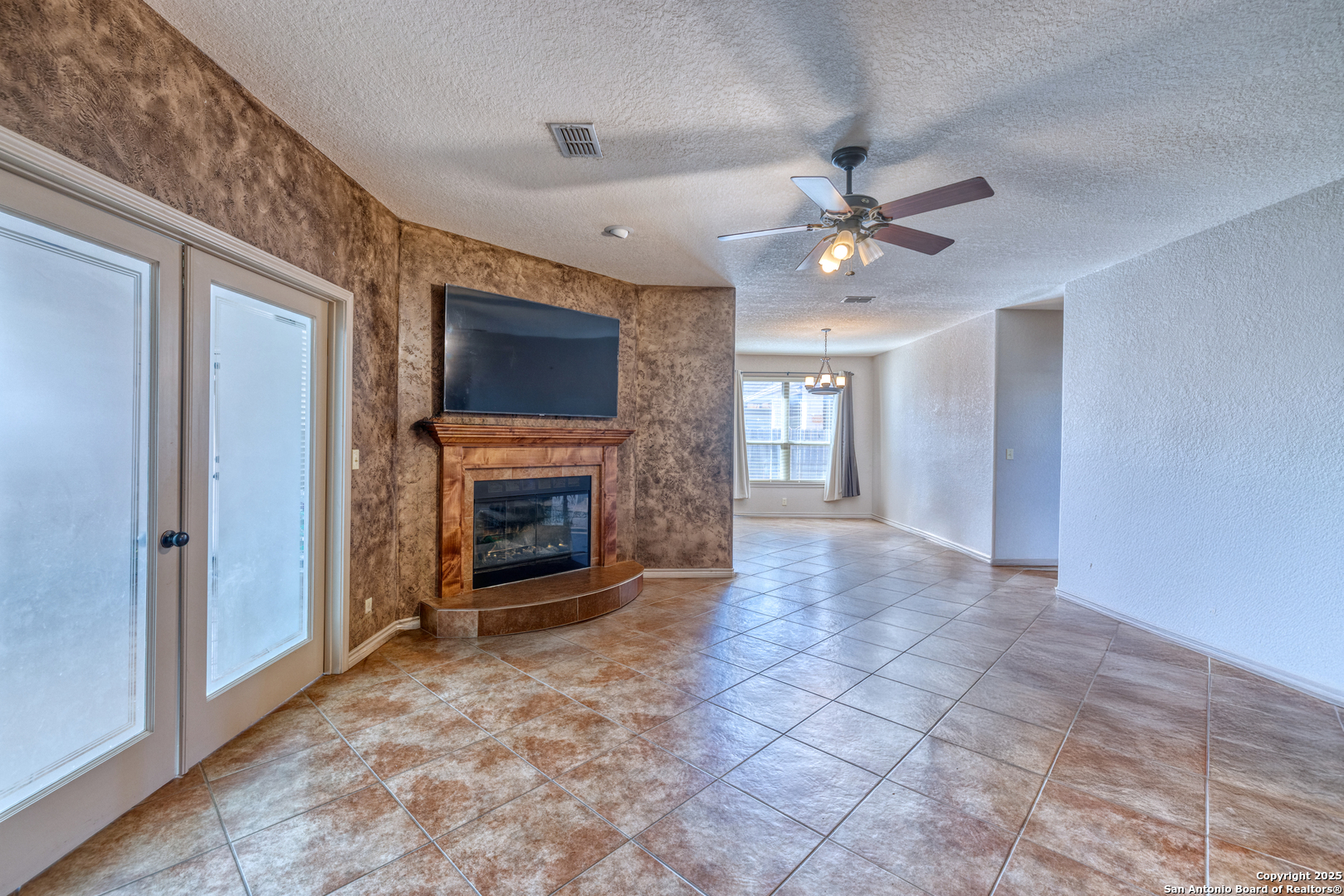 3 Briar Court Uvalde, TX 78801 - Photo 24 of 27 a view of a livingroom with a fireplace a ceiling fan and windows