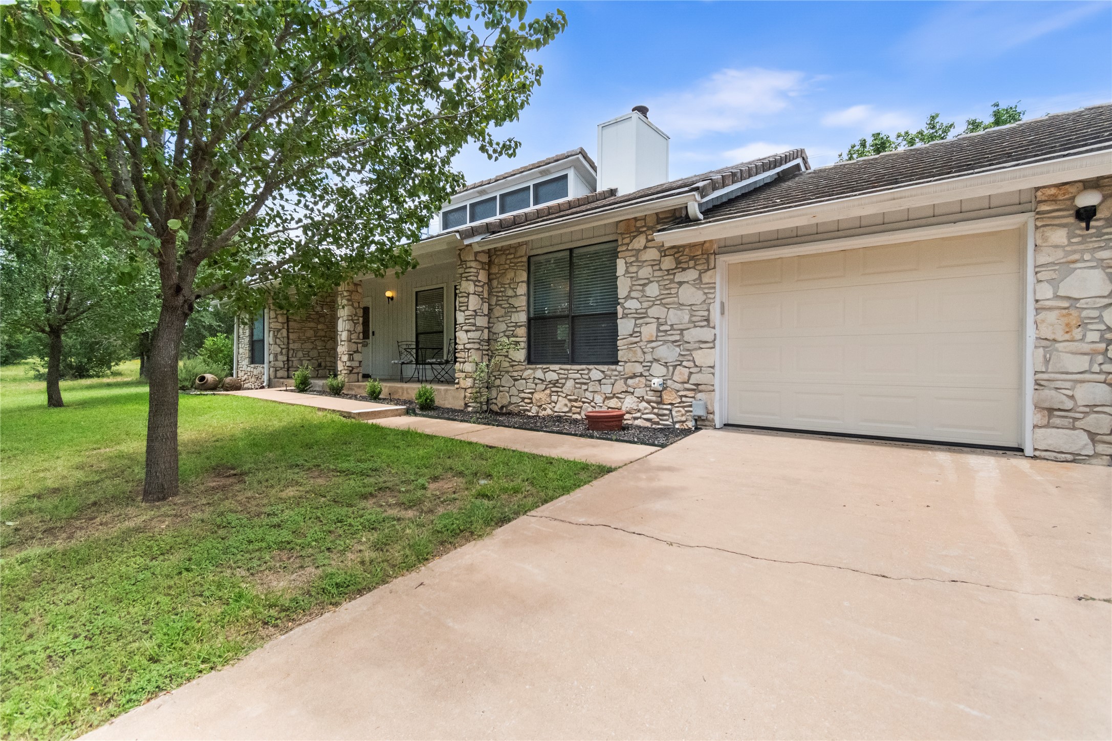 210 Teeoff, Unit B Horseshoe Bay, TX 78657 - Photo 5 of 38 A charming stone facade home offers a welcoming front porch and an attached garage.