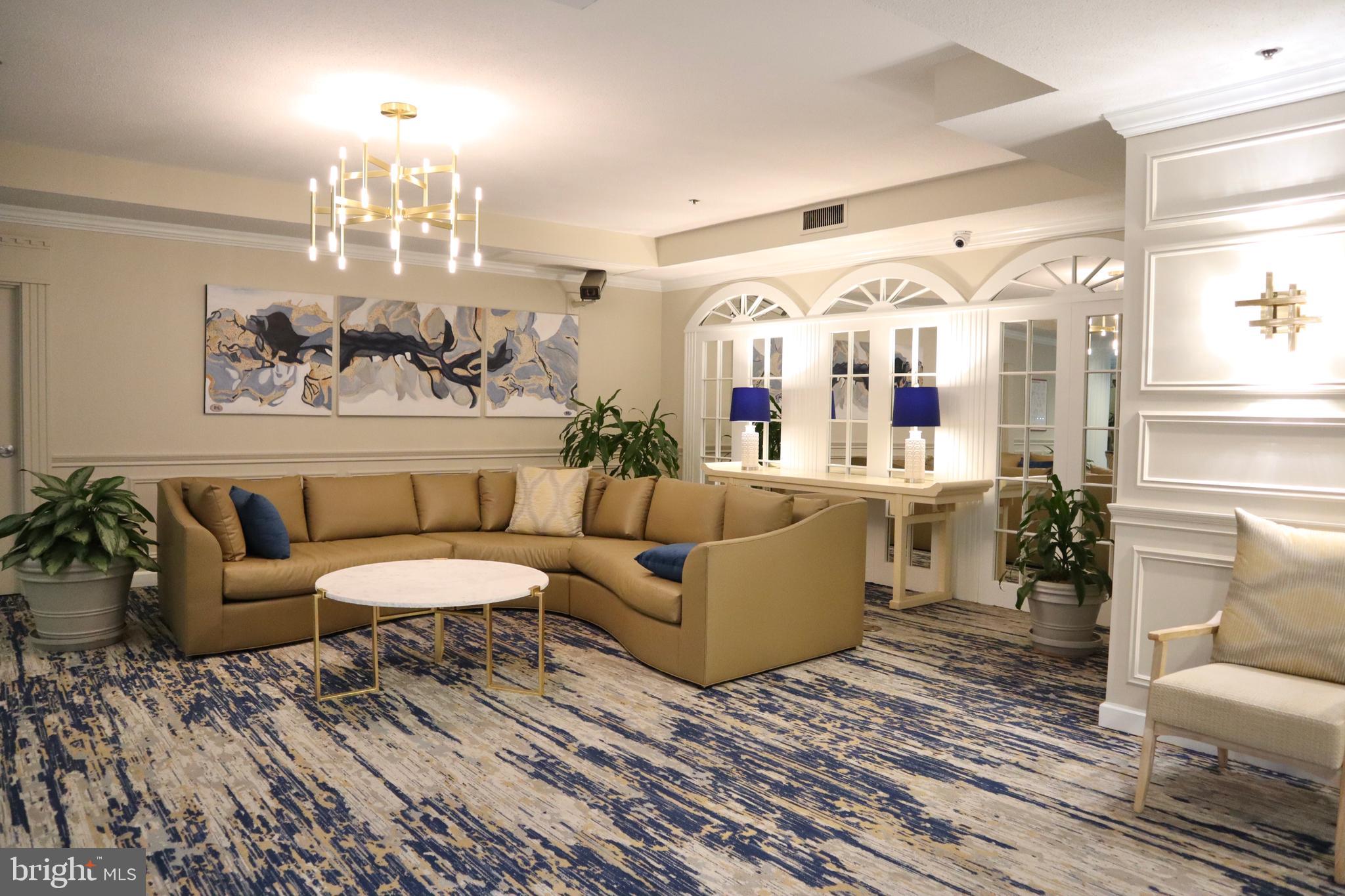 15107 Interlachen Drive, Unit 2119 Silver Spring, MD 20906 - Photo 7 of 53 a living room with furniture and a chandelier