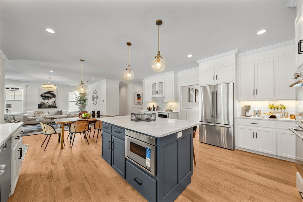 120 Lawton Road Needham, MA 02492 - Photo 5 of 34 a kitchen with stainless steel appliances a stove a sink a refrigerator and white cabinets with wooden floor