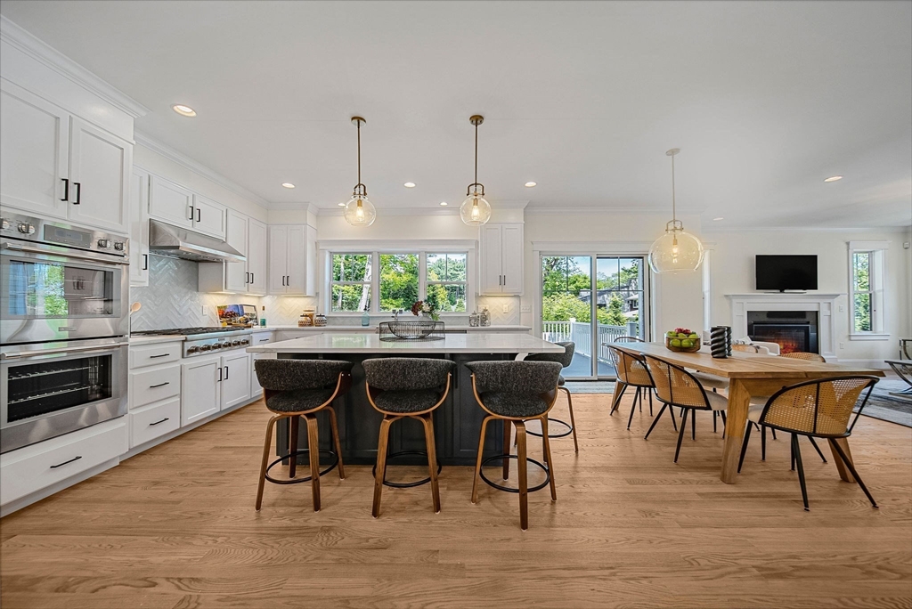 120 Lawton Road Needham, MA 02492 - Photo 7 of 34 a kitchen with stainless steel appliances granite countertop wooden floor dining table and chairs