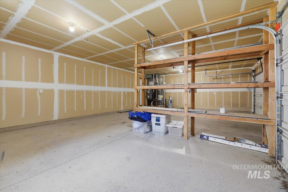 2075 North Springland Place Boise, ID 83713 - Photo 49 of 49 Spacious garage with an epoxy-coated concrete floor, exposed ceiling joists, and built-in wood shelving