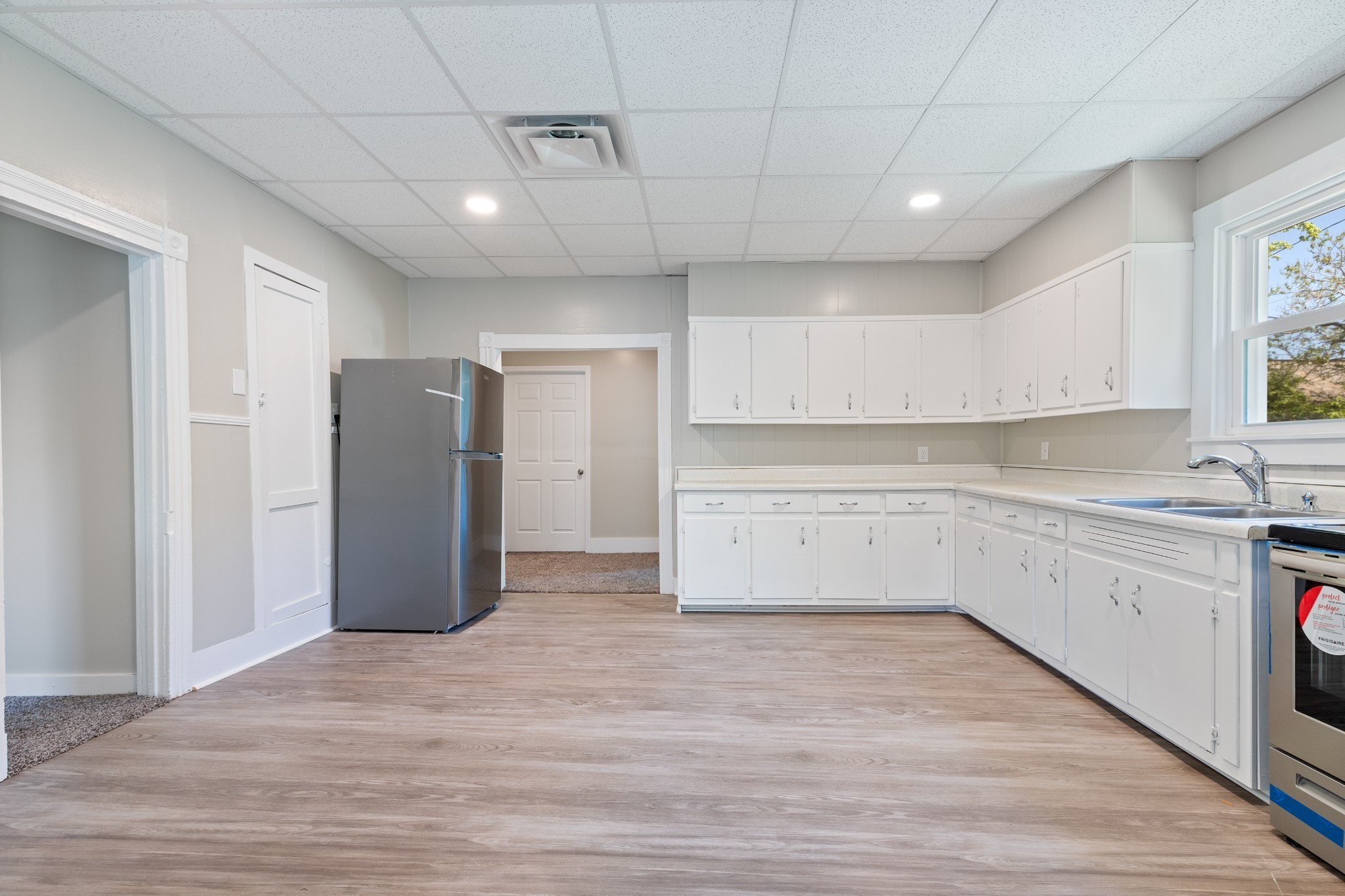 300 West Railroad Street Dickson, TN 37055 - Photo 22 of 58 a view of a kitchen with a sink and dishwasher a refrigerator with white cabinets