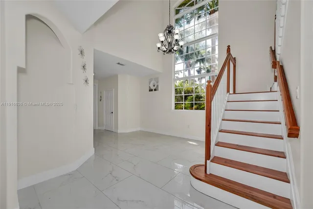 a view of a hallway with windows and stairs
