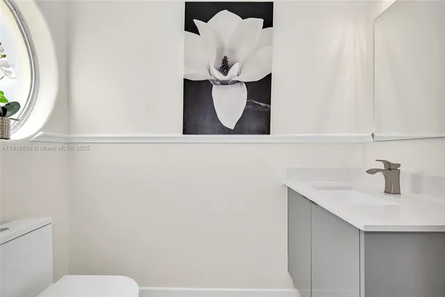a bathroom with a sink and mirror with toilet