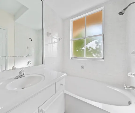 a white bath tub sitting next to a white sink and a toilet