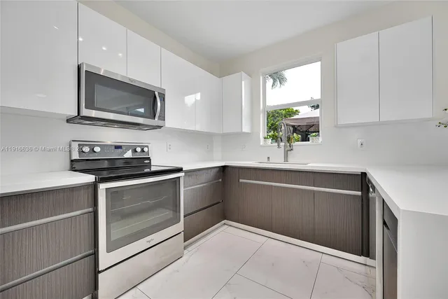 a kitchen with stainless steel appliances granite countertop a sink and a microwave