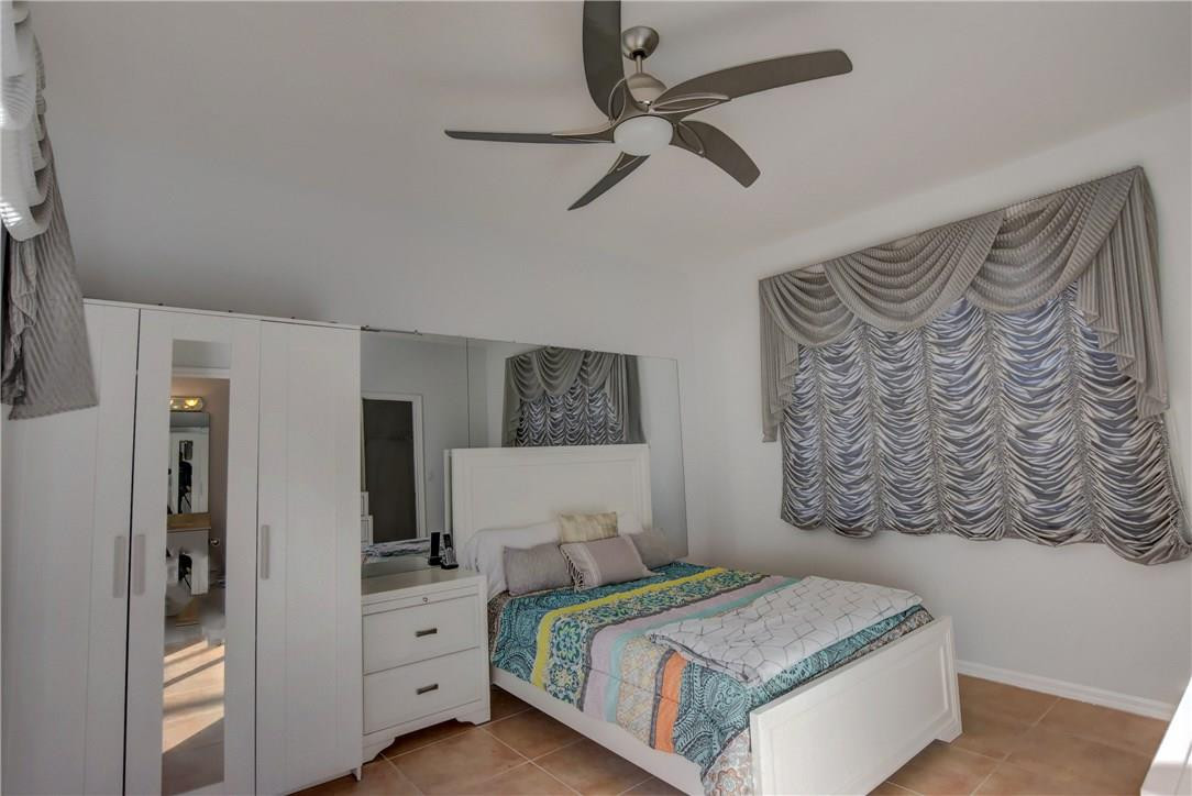 10934 Ravel Court Boca Raton, FL 33498 - Photo 39 of 43 a bedroom with a bed and a painting on the wall