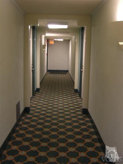 2901 Peninsula Road, Unit 242 Oxnard, CA 93035 - Photo 22 of 30 a view of a hallway with wooden floor and a bathroom