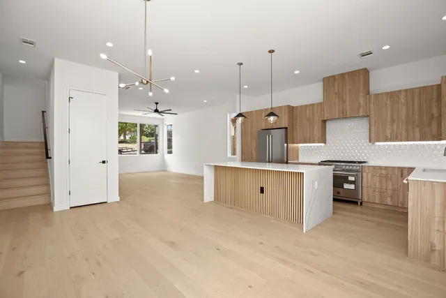 a kitchen with stainless steel appliances kitchen island a refrigerator sink and cabinets