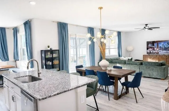 a kitchen with stainless steel appliances a table chairs refrigerator and microwave