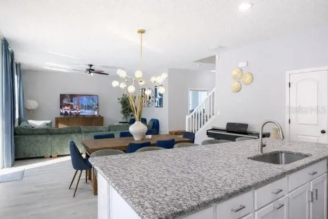 a kitchen with a table chairs and a chandelier