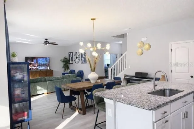 a kitchen with stainless steel appliances granite countertop a refrigerator a sink a stove and a refrigerator