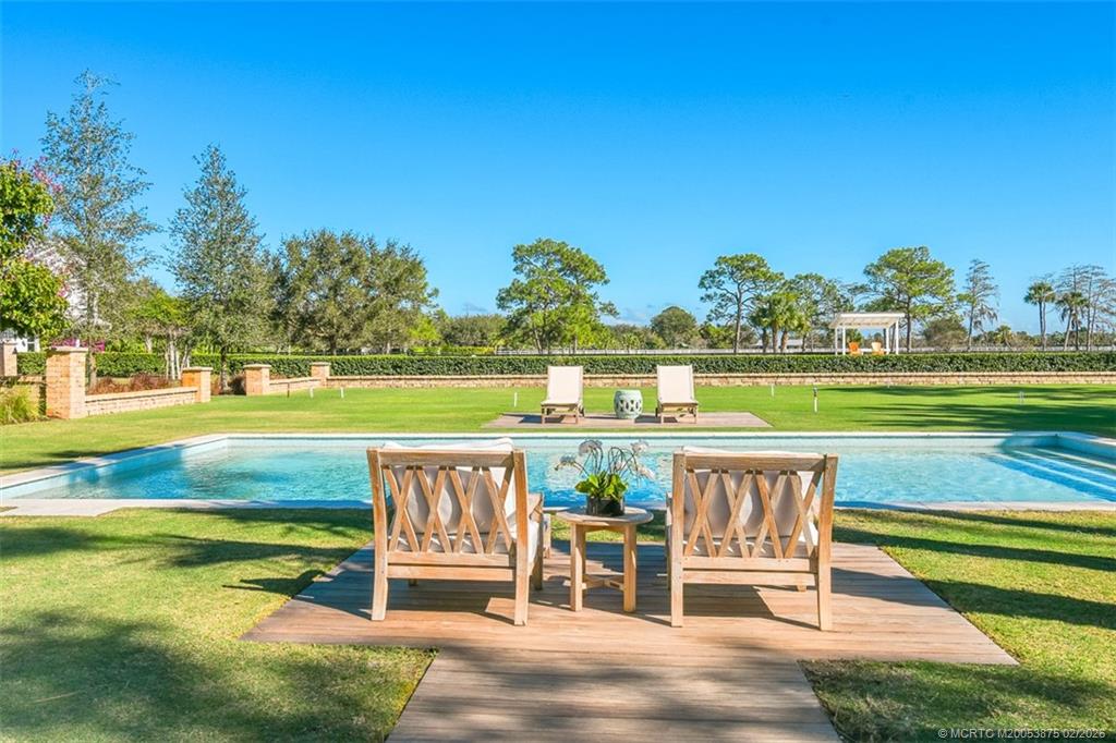 2541 Southwest Trailside Path Stuart, FL 34997 - Photo 72 of 100 a view of a swimming pool with a lounge chairs
