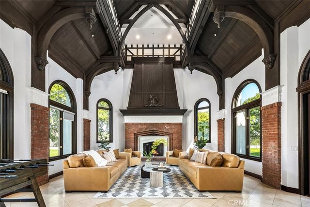 a living room with furniture fireplace and large windows
