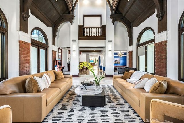 a living room with furniture a fireplace and a chandelier