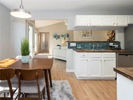 a kitchen with granite countertop white cabinets and chairs