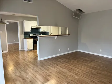 a kitchen with granite countertop a refrigerator and a stove top oven