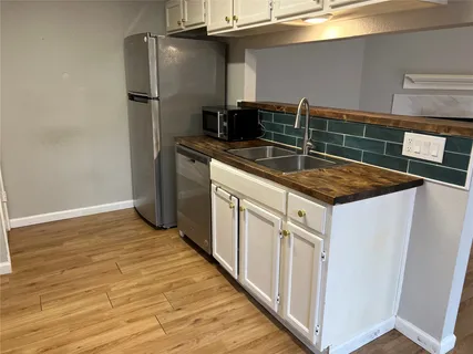 a kitchen with stainless steel appliances granite countertop a sink and a refrigerator