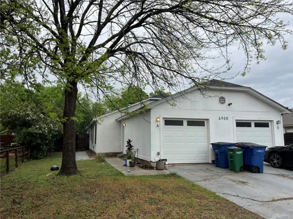 a front view of house with yard and trees in the background