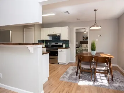 a kitchen with kitchen island a dining table chairs and a wooden floor