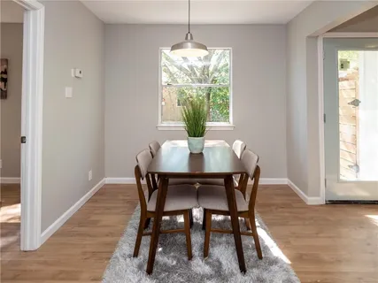 a dining room with furniture window and wooden floor