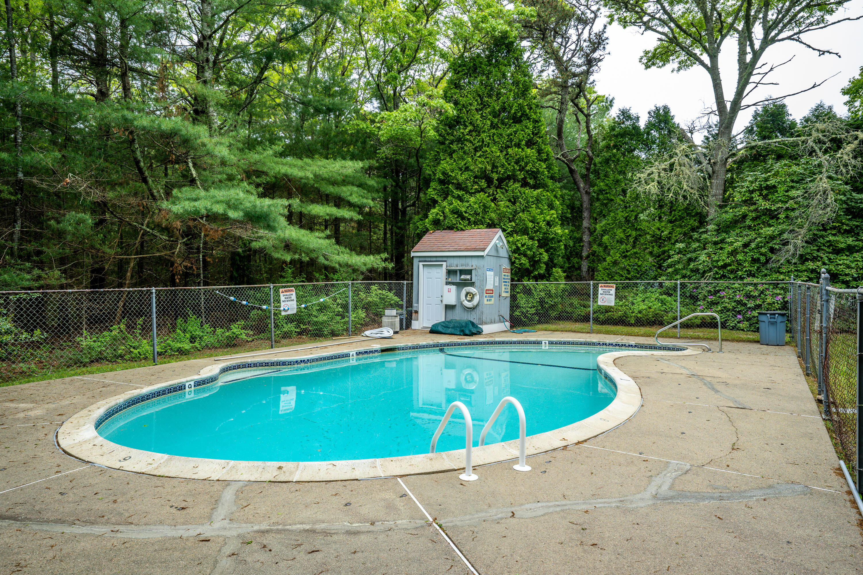 70 Cape Drive, Unit 12D Mashpee, MA 02649 - Photo 11 of 13 a view of a swimming pool and trees in the background