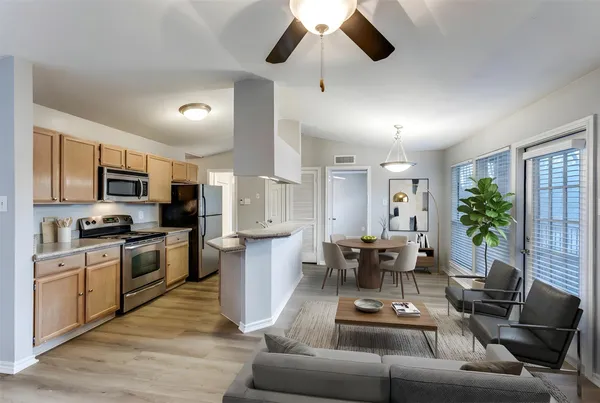 a living room with furniture kitchen and a wooden floor