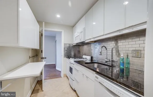 a kitchen with stainless steel appliances a sink a stove and cabinets