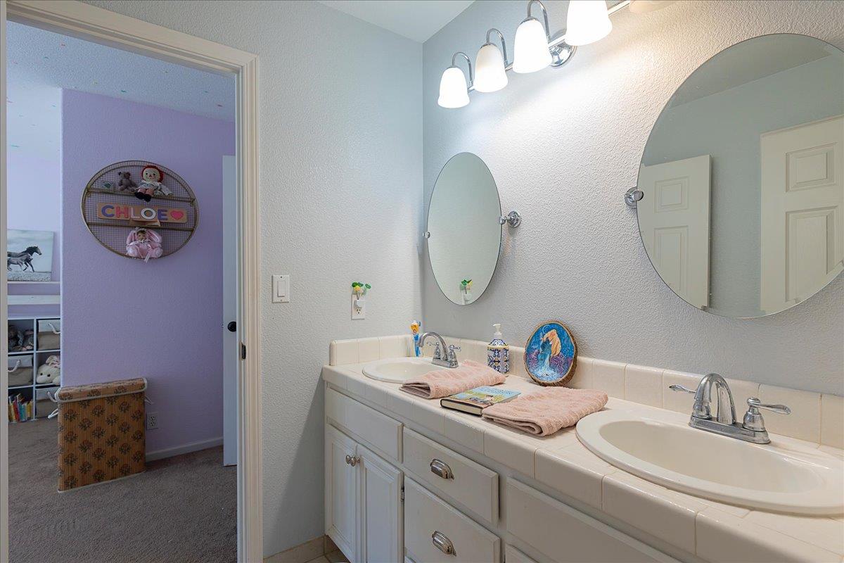 2565 Bertella Road Cameron Park, CA 95682 - Photo 24 of 31 a bathroom with a double vanity sink and a mirror