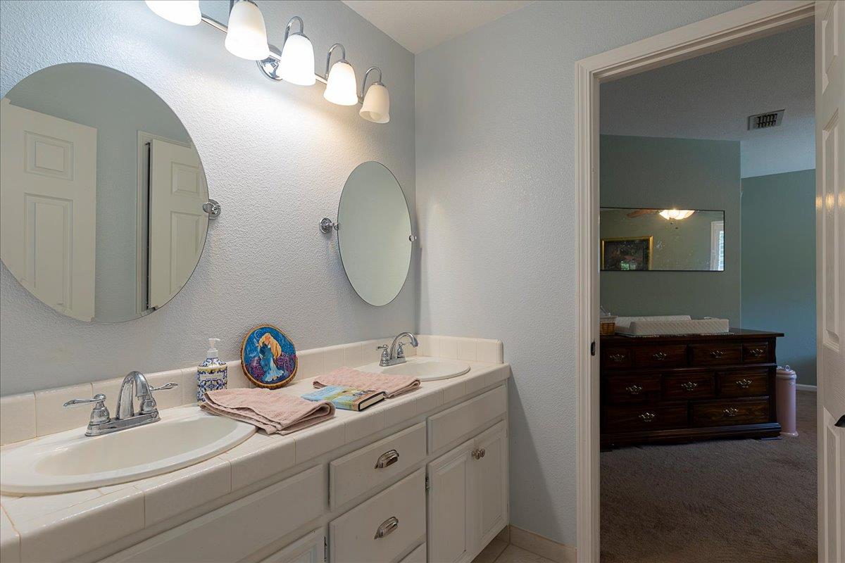 2565 Bertella Road Cameron Park, CA 95682 - Photo 25 of 31 a bathroom with a double vanity sink and a mirror