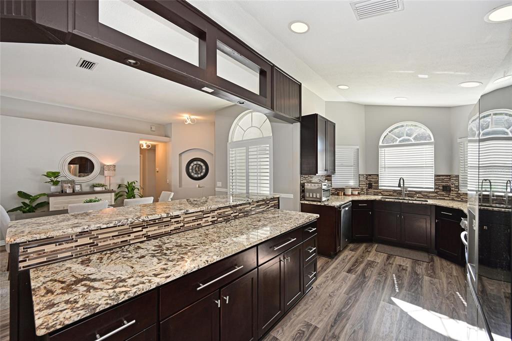12709 Nightshade Place Lakewood Ranch, FL 34202 - Photo 11 of 53 a kitchen with stainless steel appliances granite countertop sink stove and refrigerator