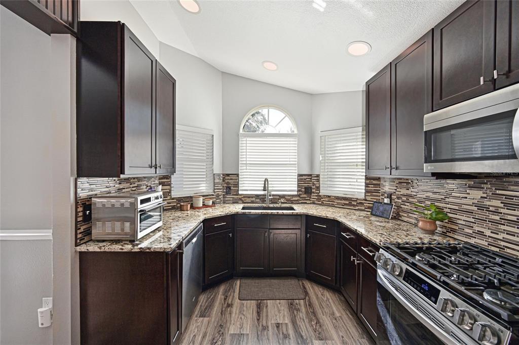 12709 Nightshade Place Lakewood Ranch, FL 34202 - Photo 12 of 53 a kitchen with a sink stove top oven and refrigerator